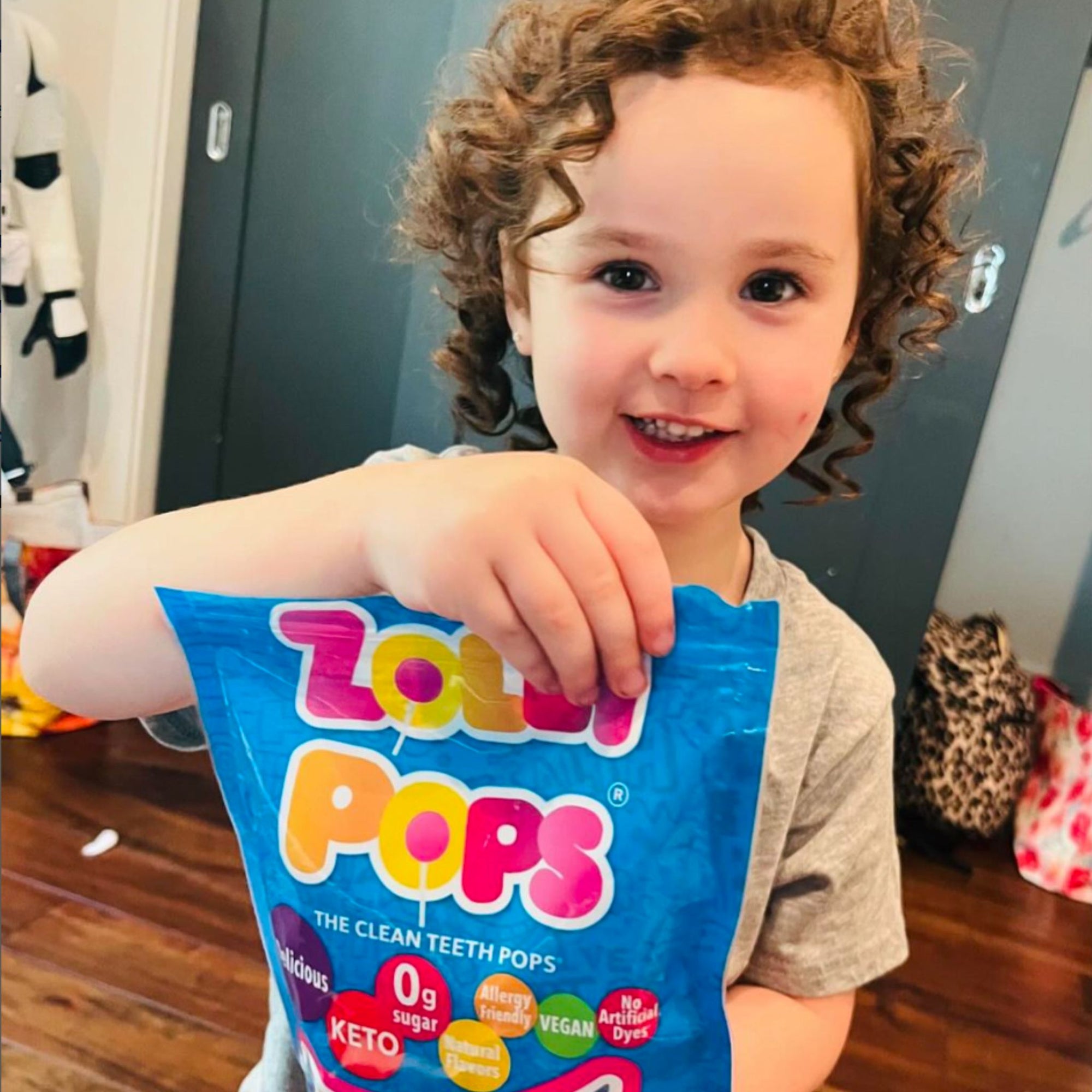 Child holding a bag of Zollipops.