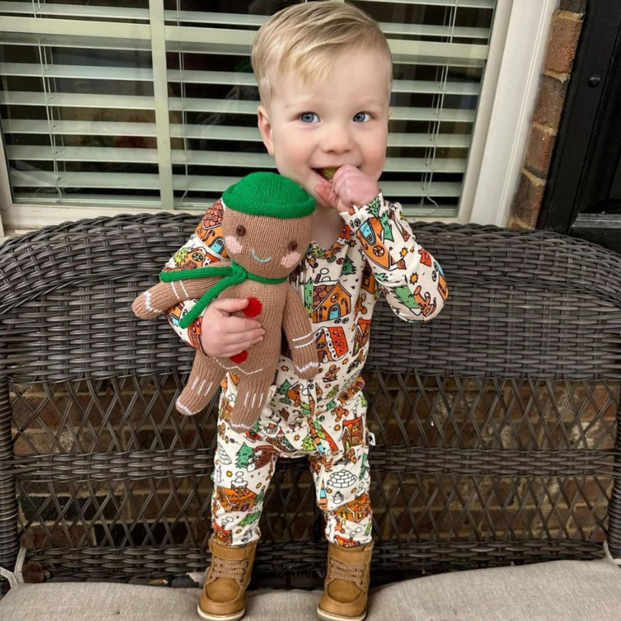 Child with a zollipop and gingerbread man plushie.