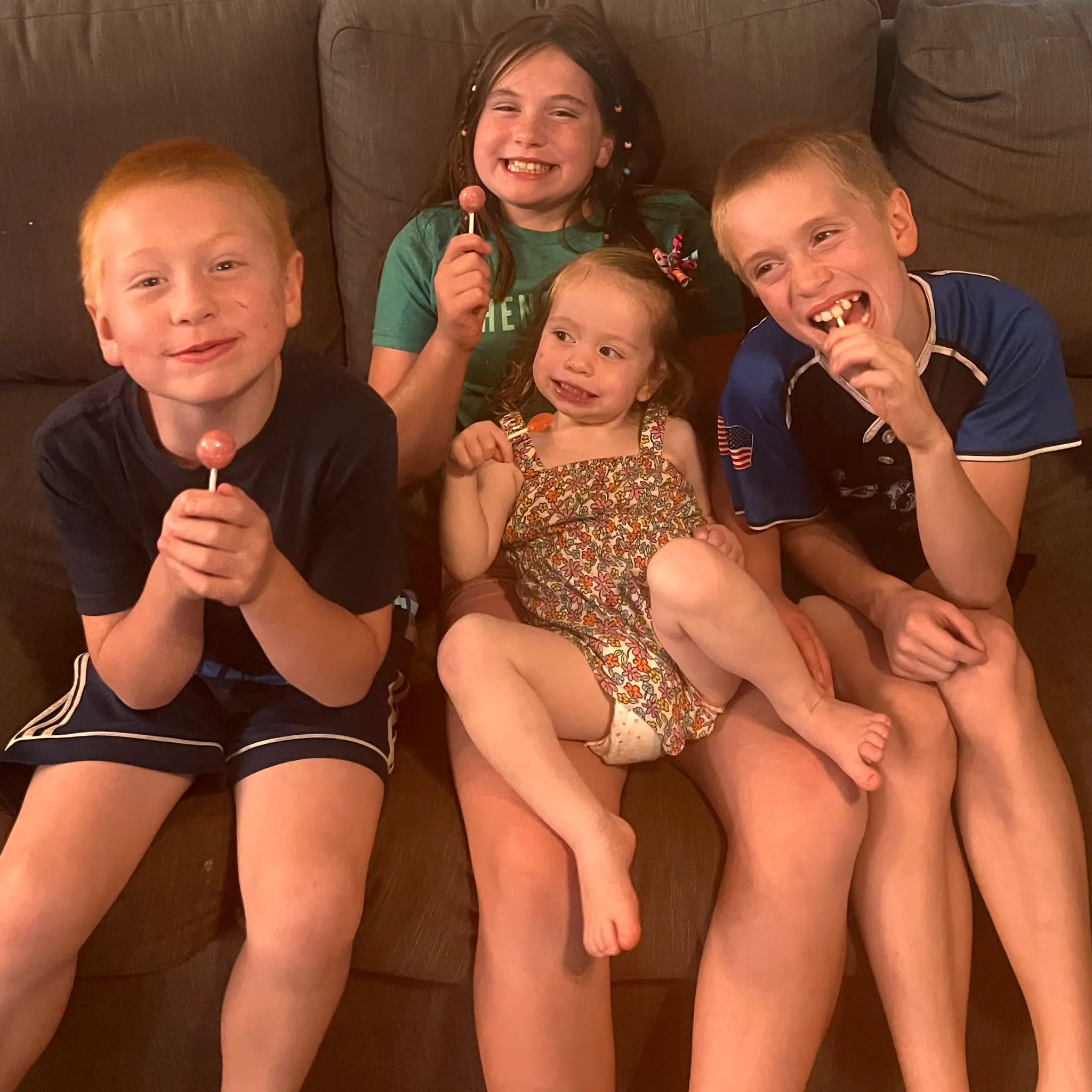 Four kids eating zollipops and gum pops.