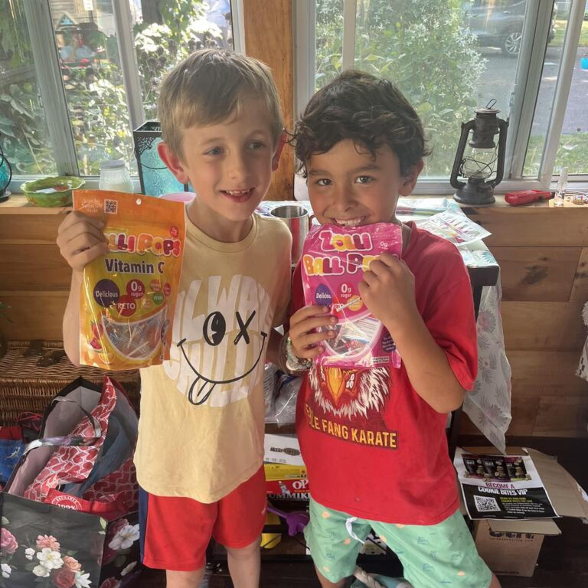 Children with a bag of zolli ball pops and bag of vitamin c lollipops.