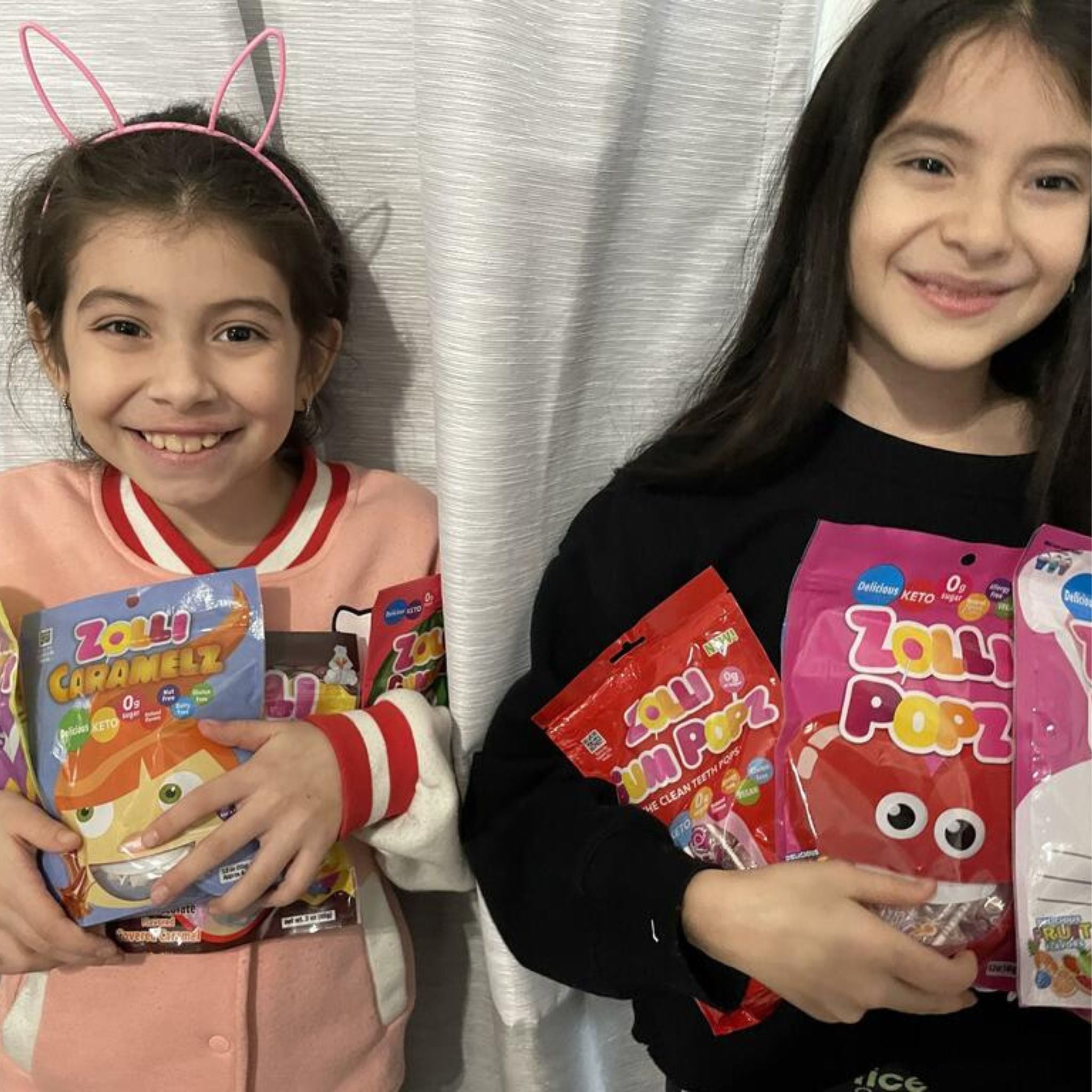 Two girls with bags of zolli candy.