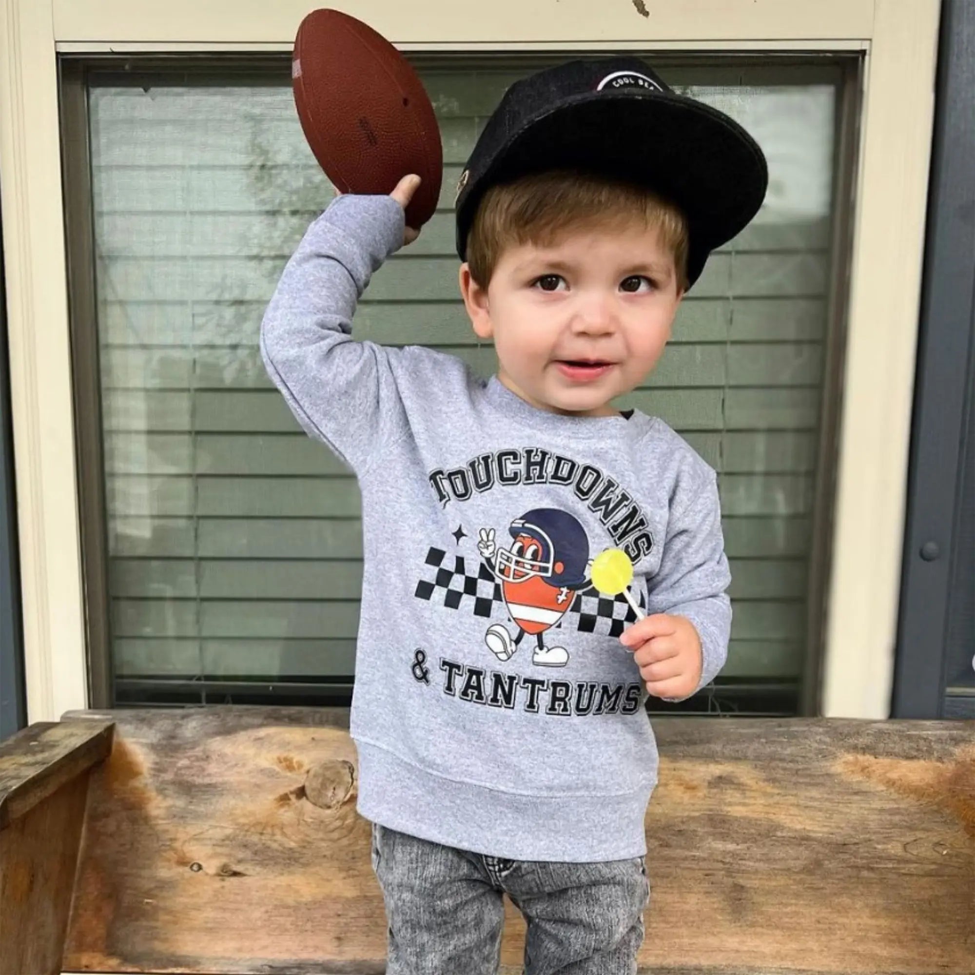 Child with a football and a zollipop.