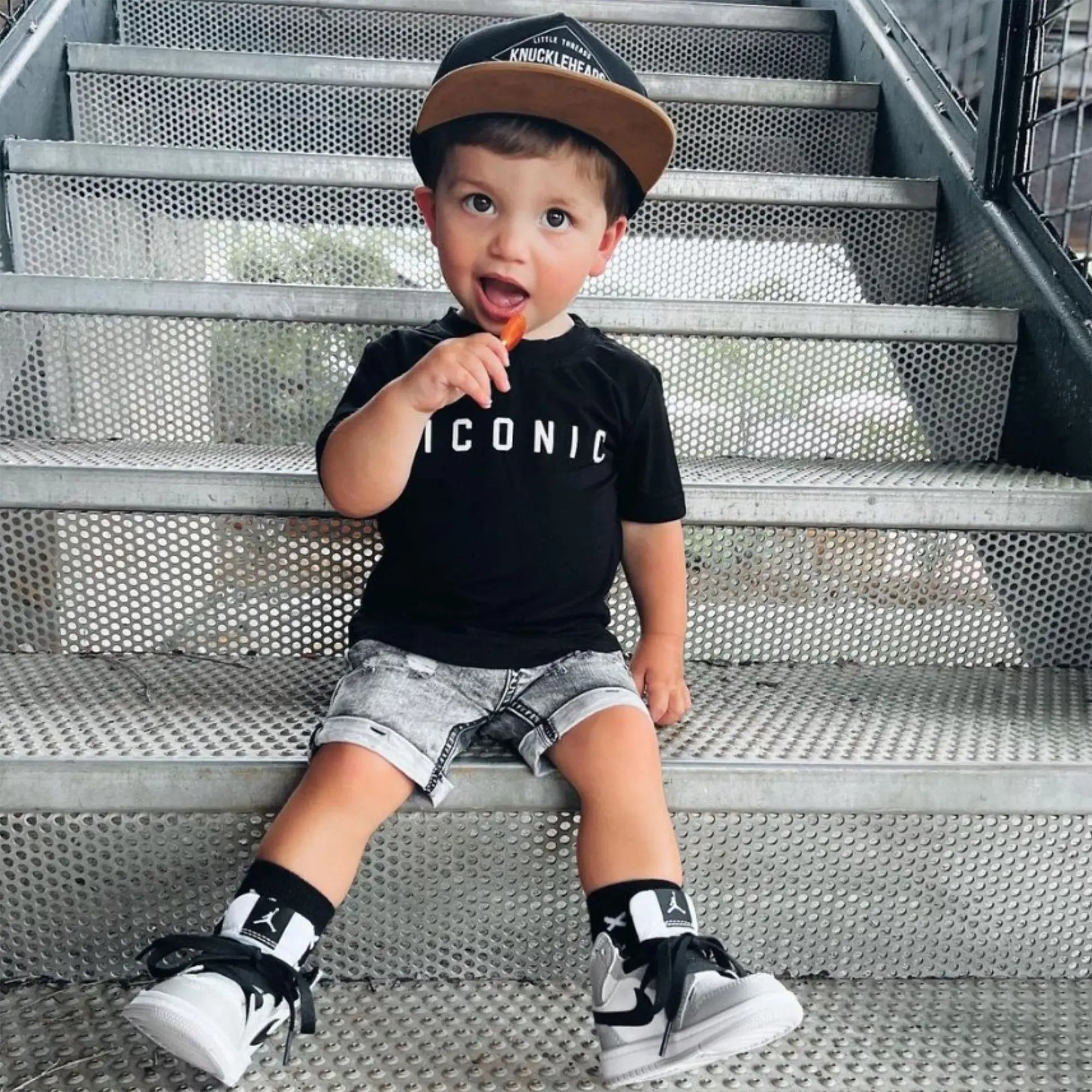 Child with zollipops on step.