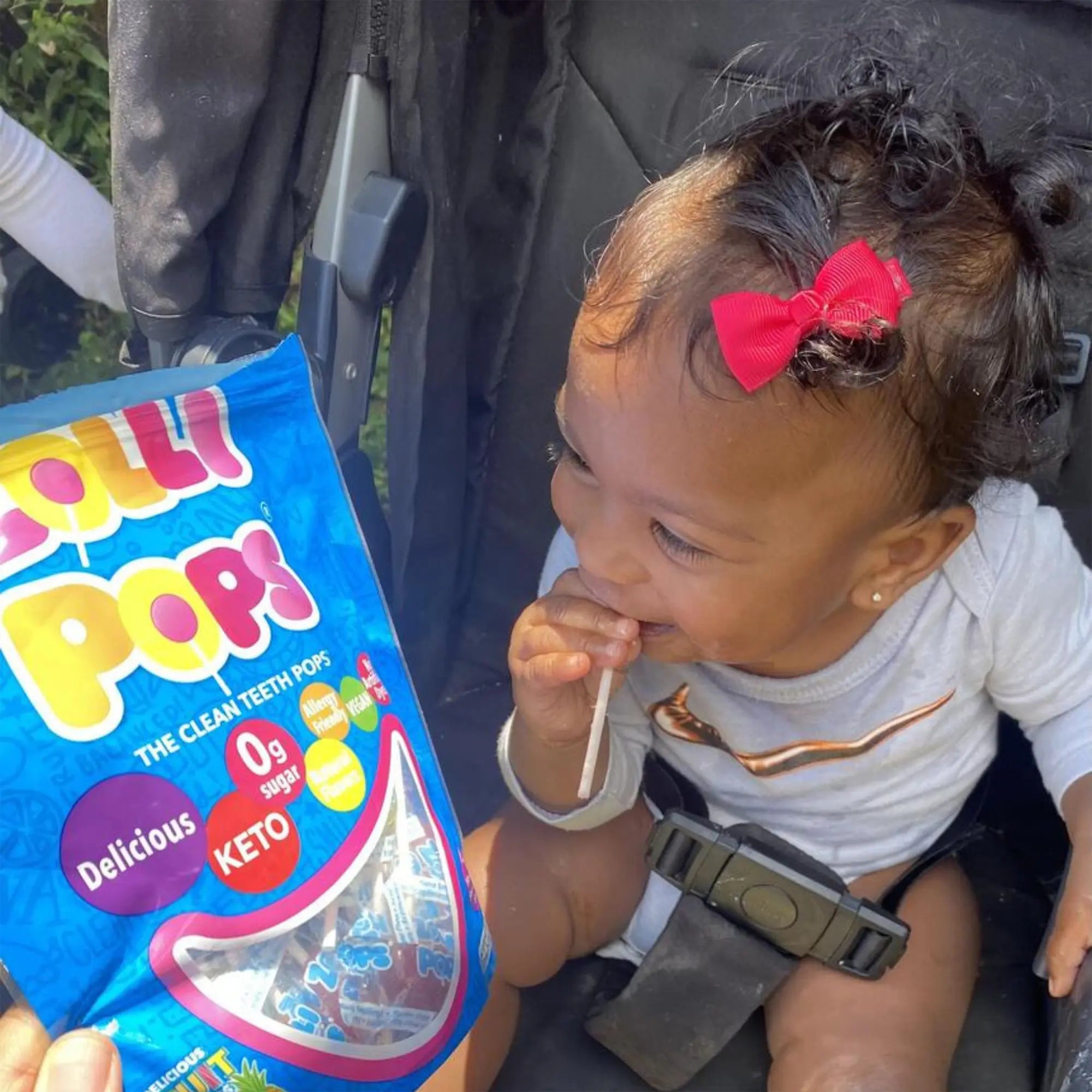 Child in stroller with zollipop.