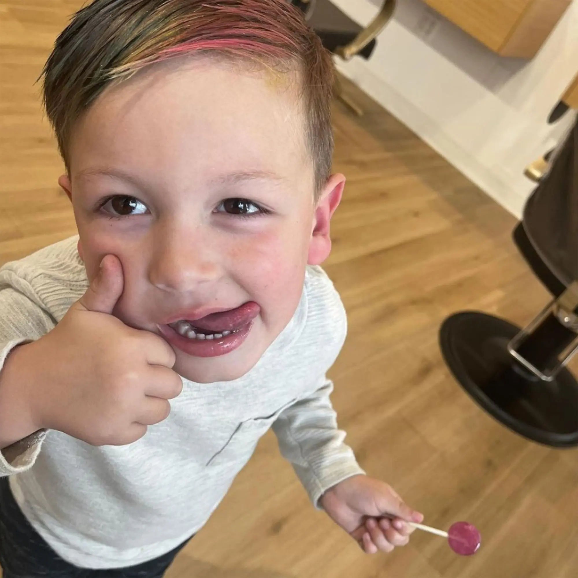 Child at hair salon with a zollipop.