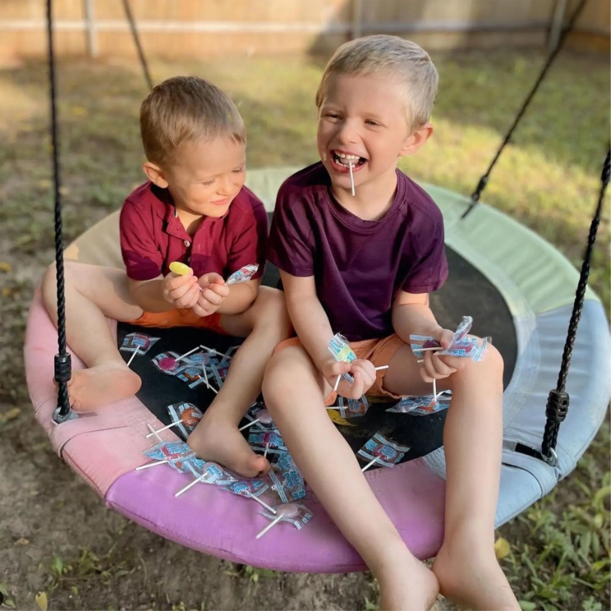 Kids on swing with zollipops.