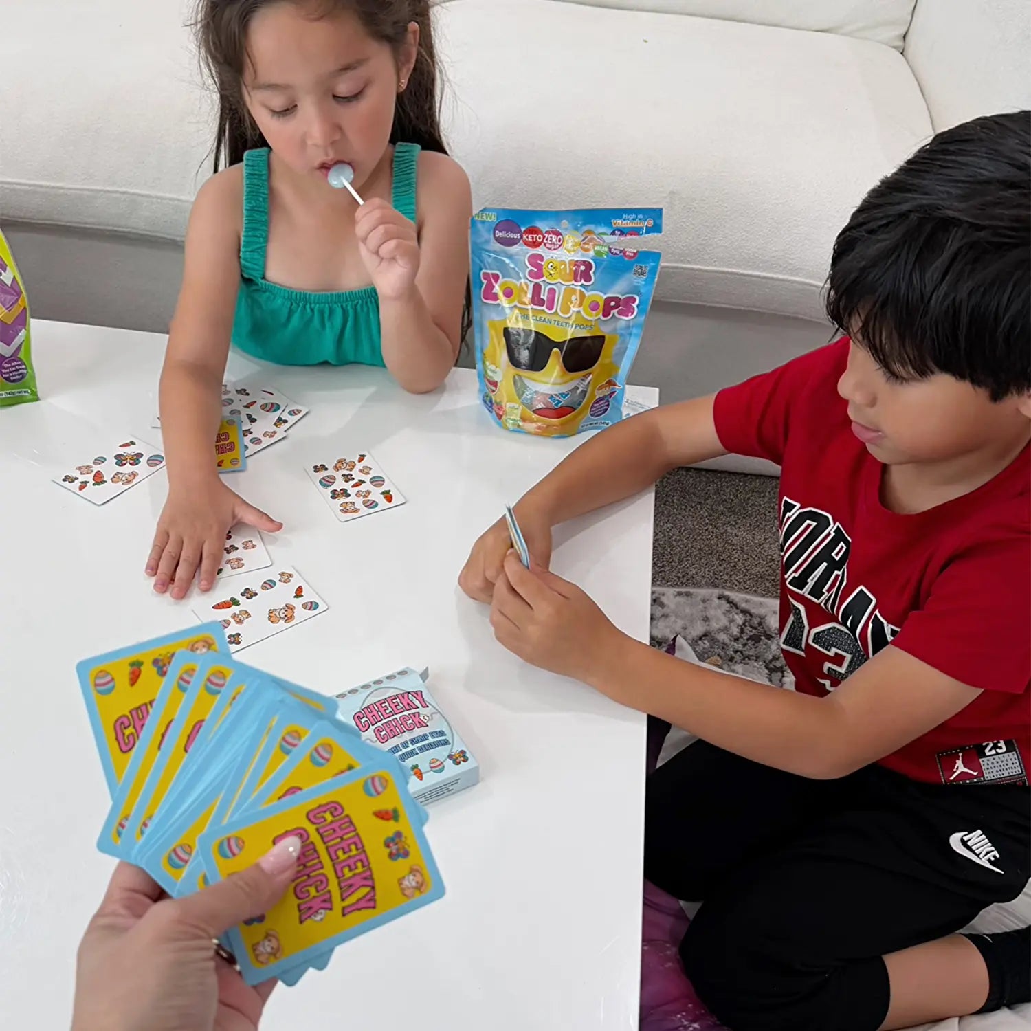 Kids with sour zollipops, playing cards.