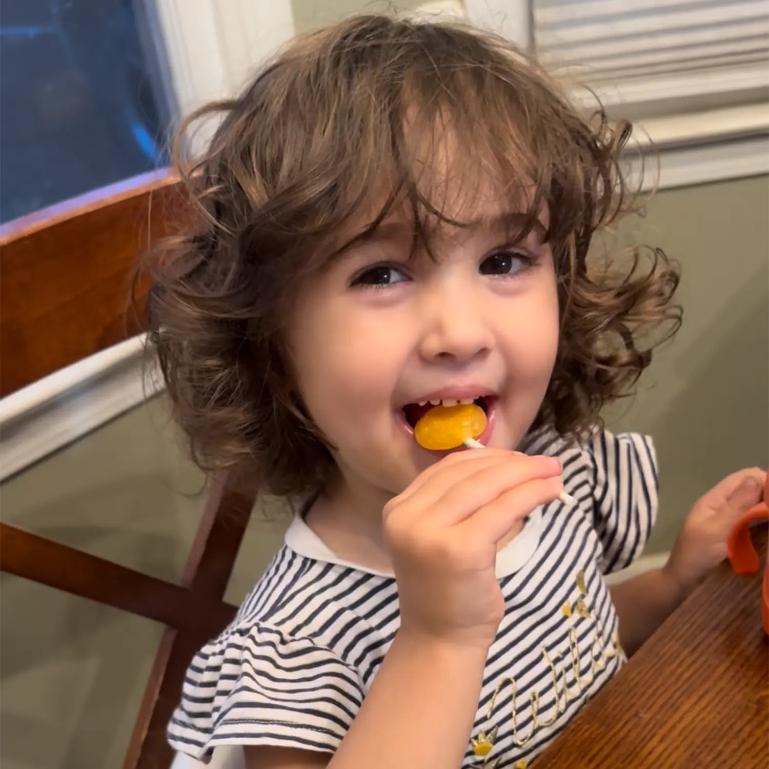 Girl eating a zollipop.